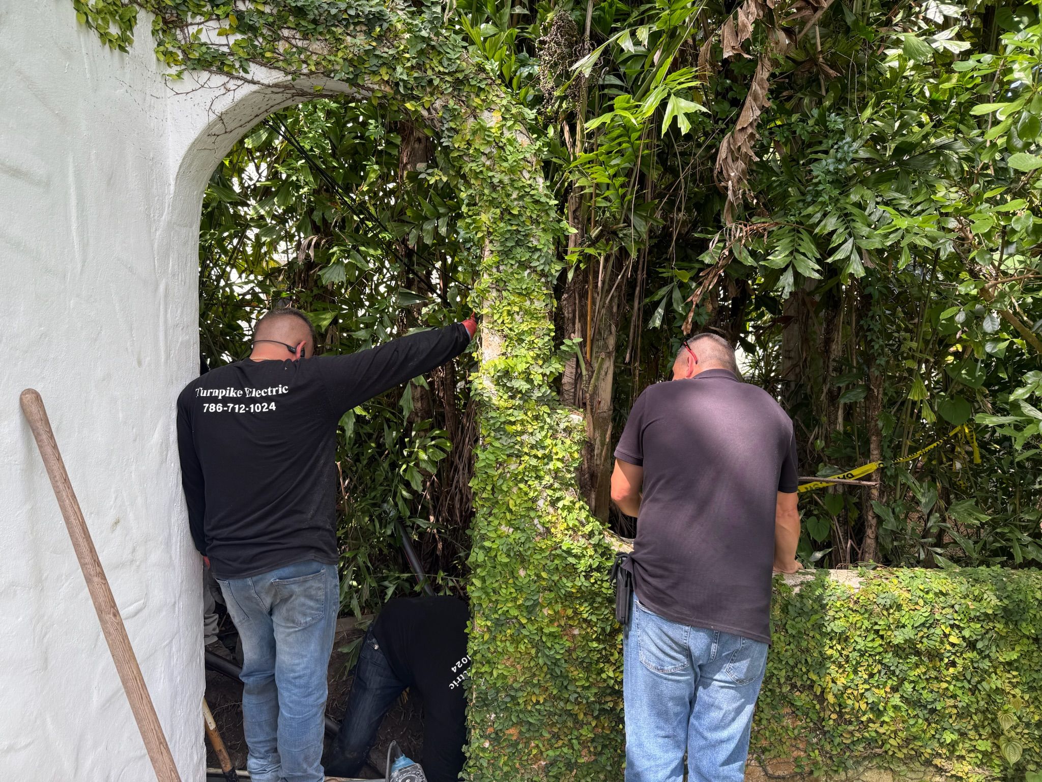 Crew coordinating an underground service run through a garden